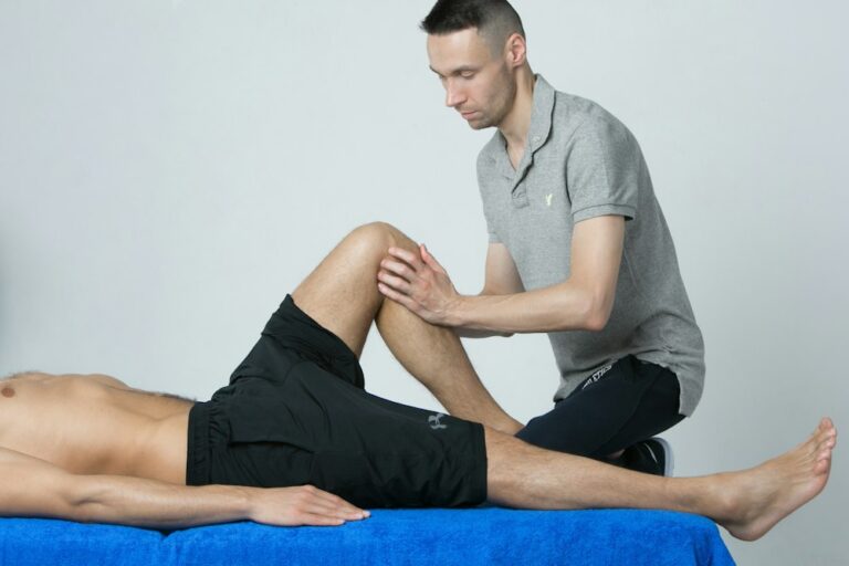 Physiotherapist assessing a client’s leg during an initial assessment